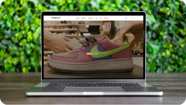 Sneakershyllan online store displayed on a laptop in front of a green wall